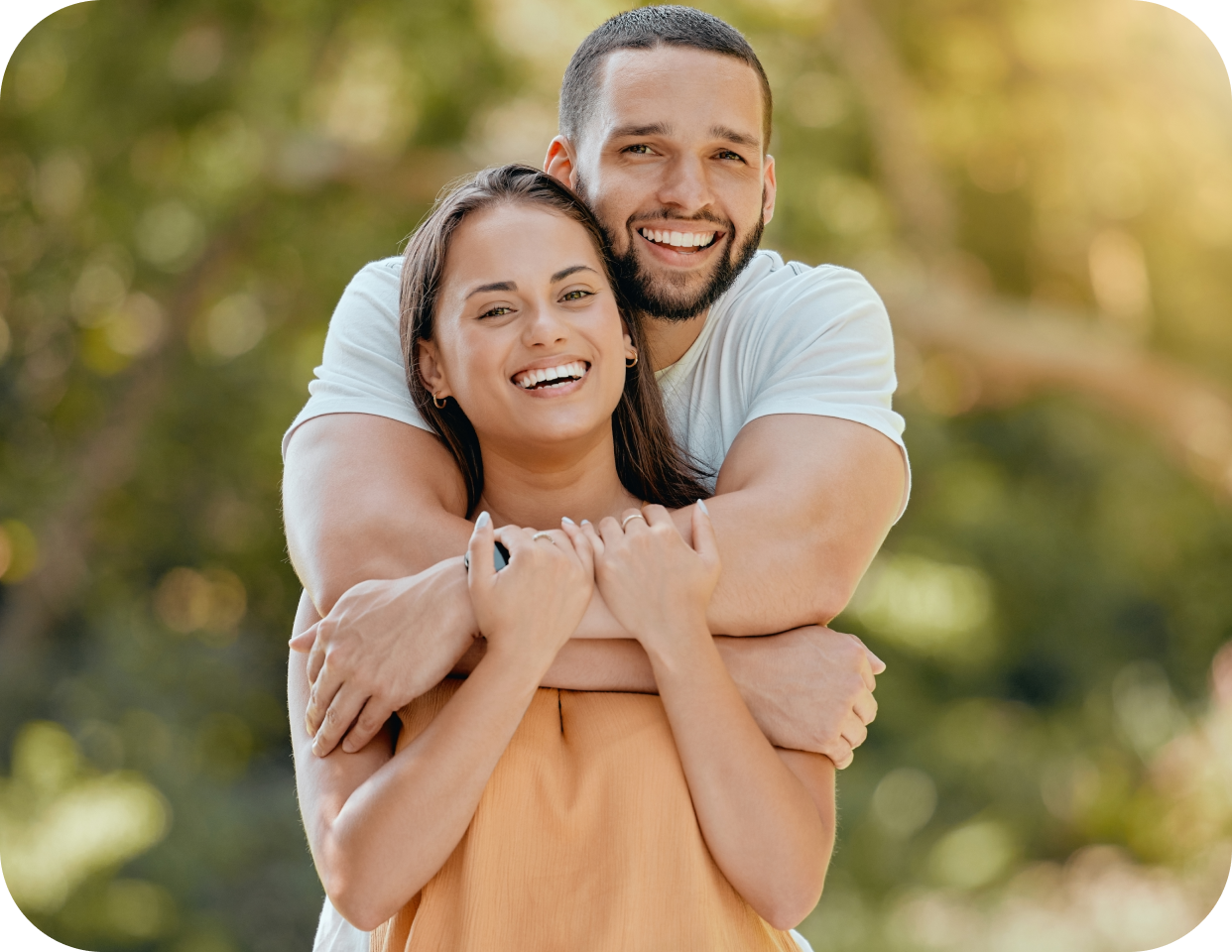 A man and woman hugging in the park.