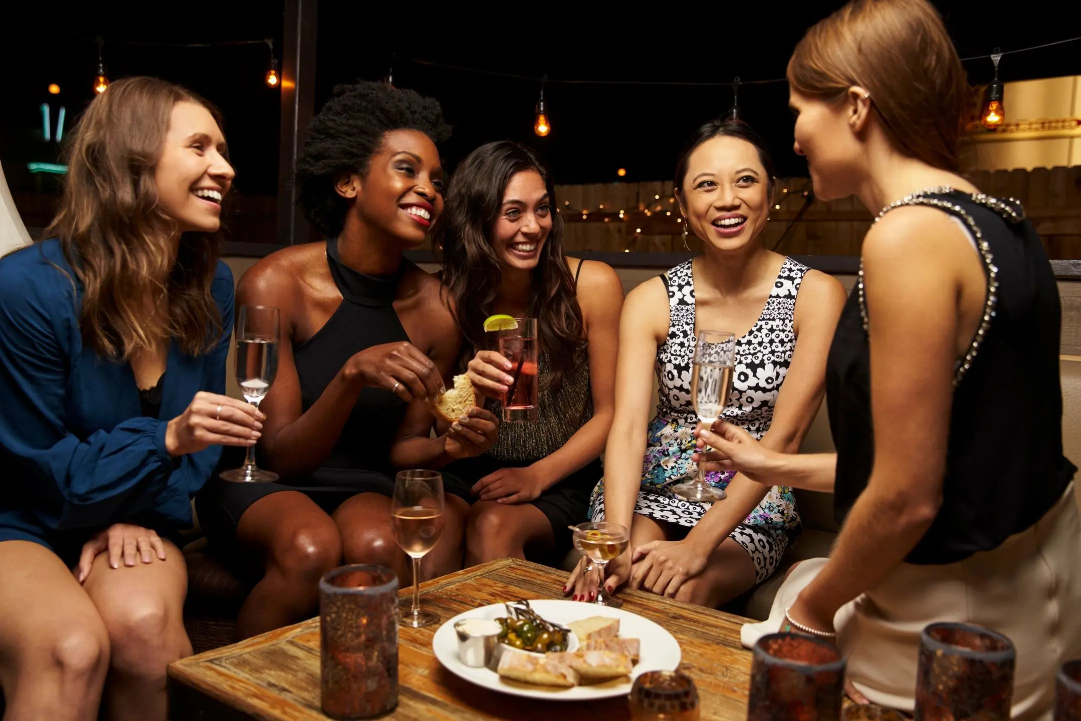 A group of women sitting around a table with drinks.