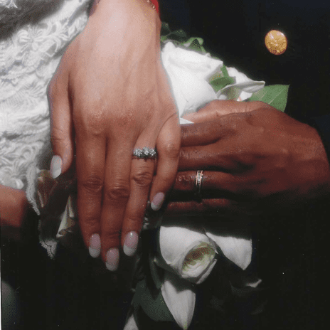 A close up of two hands with wedding rings