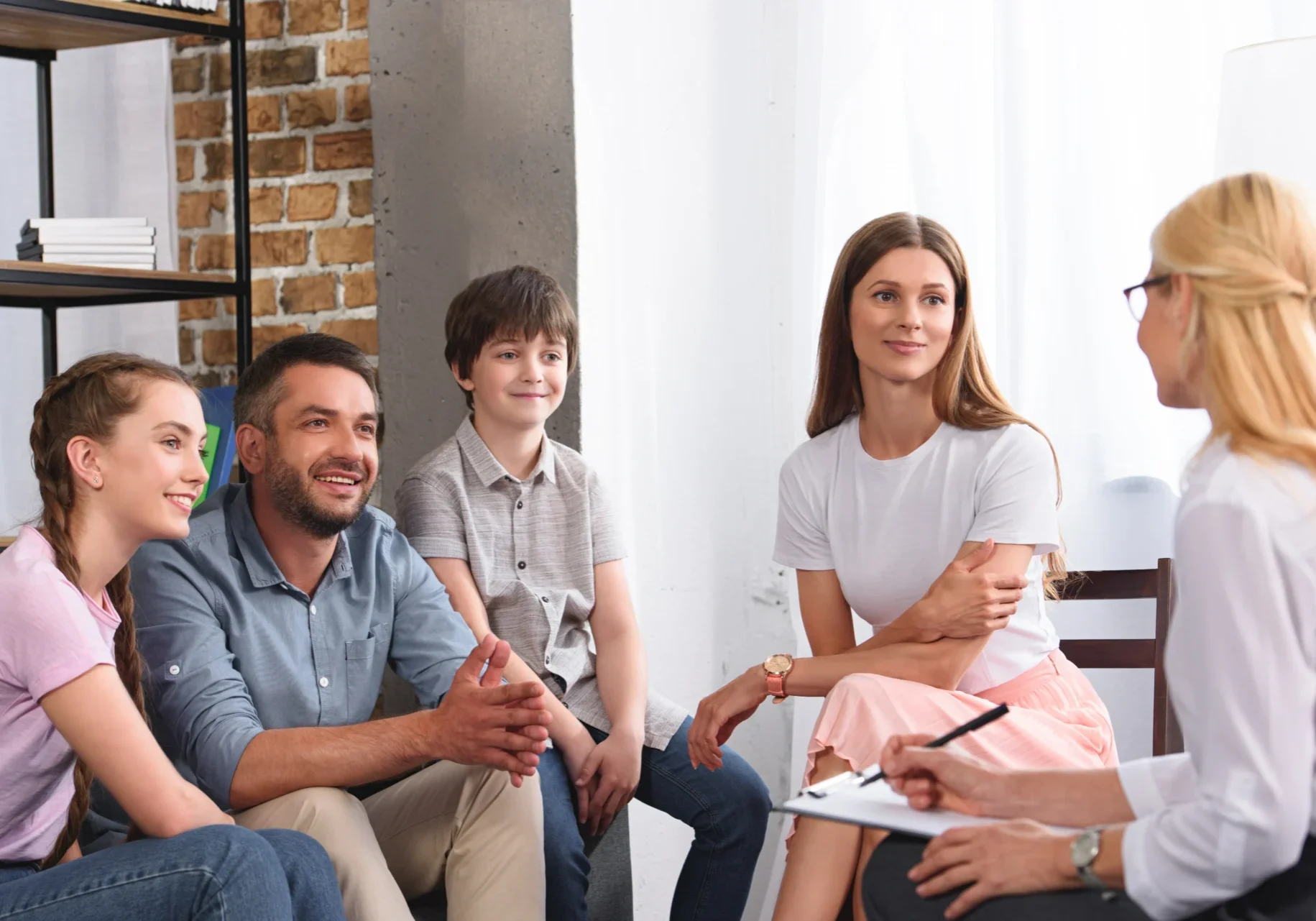 A group of people sitting around each other.