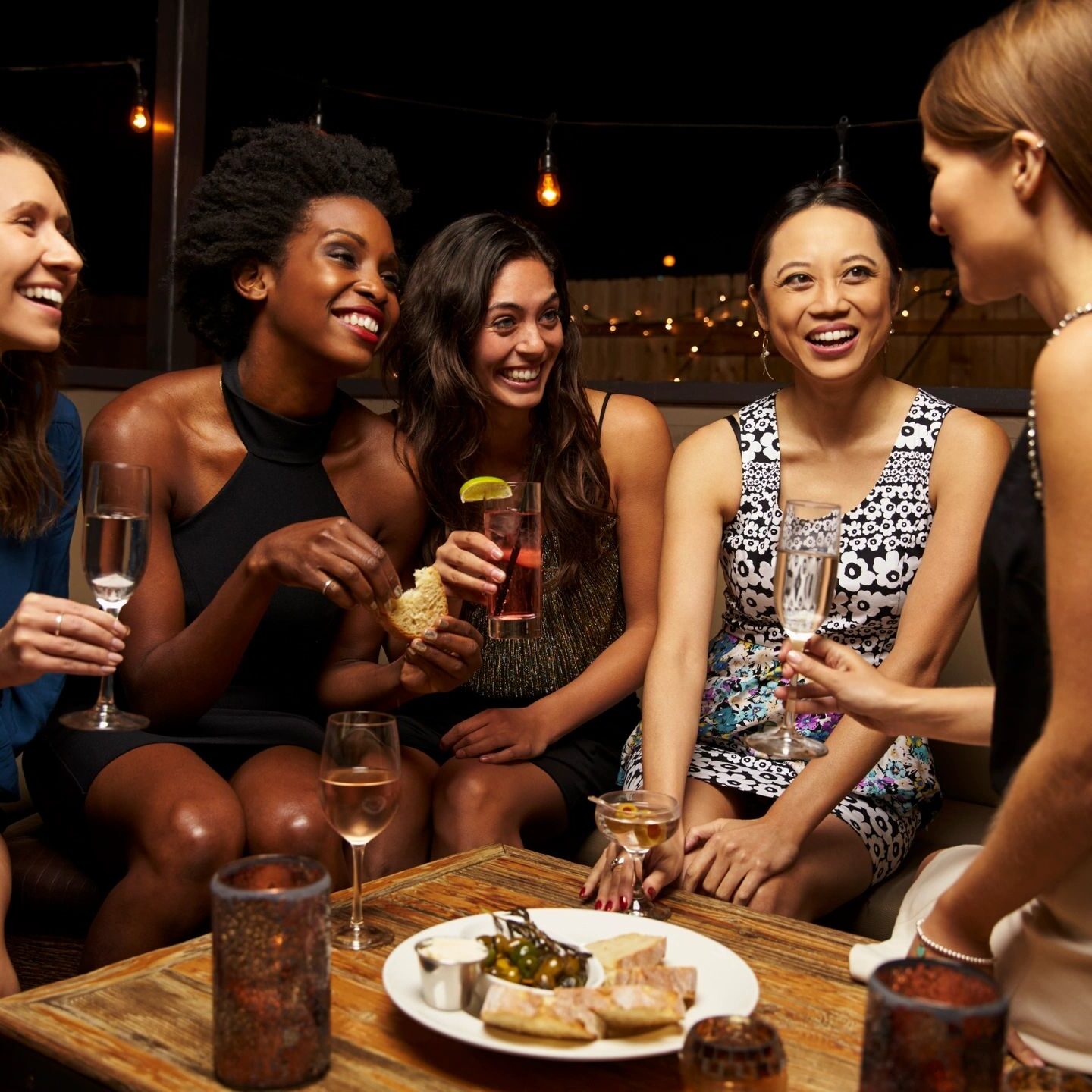 A group of women sitting around a table with drinks.